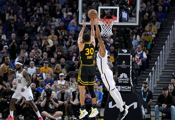 SAN FRANCISCO, CALIFORNIA - DECEMBER 16: Stephen Curry #30 of the Golden State Warriors shoots over Nic Claxton #33 of the Brooklyn Nets during the fourth quarter of an NBA basketball game at Chase Center on December 16, 2023 in San Francisco, California. NOTE TO USER: User expressly acknowledges and agrees that, by downloading and or using this photograph, User is consenting to the terms and conditions of the Getty Images License Agreement. (Photo by Thearon W. Henderson/Getty Images)