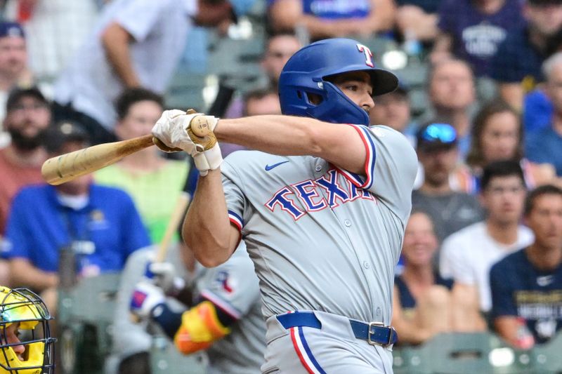Jun 25, 2024; Milwaukee, Wisconsin, USA; Texas Rangers third baseman Josh H. Smith (8) hits a RBI single in the first inning against the Milwaukee Brewers at American Family Field. Mandatory Credit: Benny Sieu-USA TODAY Sports