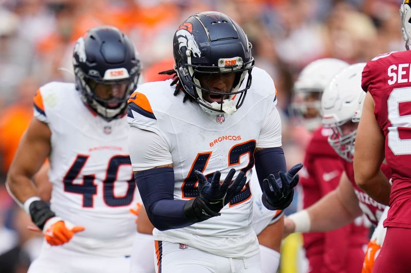 Denver Broncos linebackers Nik Bonitto, right, and Justin Strnad (40) celebrate a defensive stop against the Arizona Cardinals during the first half of a preseason NFL football game Sunday, Aug. 25, 2024, in Denver. (AP Photo/Jack Dempsey)