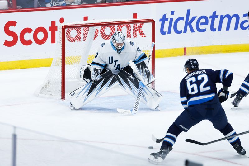 Nov 5, 2024; Winnipeg, Manitoba, CAN;  Winnipeg Jets forward Nino Niederreiter (62) skates in on Utah Hockey Club goalie Karel Vejmelka (70) during the third period at Canada Life Centre. Mandatory Credit: Terrence Lee-Imagn Images