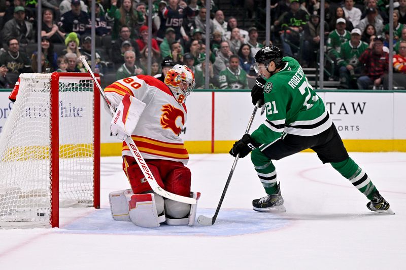 Mar 6, 2025; Dallas, Texas, USA; Dallas Stars left wing Jason Robertson (21) scores the game winning goal against Calgary Flames goaltender Dan Vladar (80) during the overtime period at the American Airlines Center. Mandatory Credit: Jerome Miron-Imagn Images