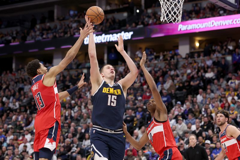 DENVER, COLORADO - FEBRUARY 22: Nikola Jokic #15 of the Denver Nuggets puts up a shot against Jordan Poole #13 and Bilal Coulibaly #0 of the Washington Wizards in the fourth quarter at Ball Arena on February 22, 2024 in Denver, Colorado. NOTE TO USER: User expressly acknowledges and agrees that, by downloading and or using this photograph, User is consenting to the terms and conditions of the Getty Images License Agreement. (Photo by Matthew Stockman/Getty Images)