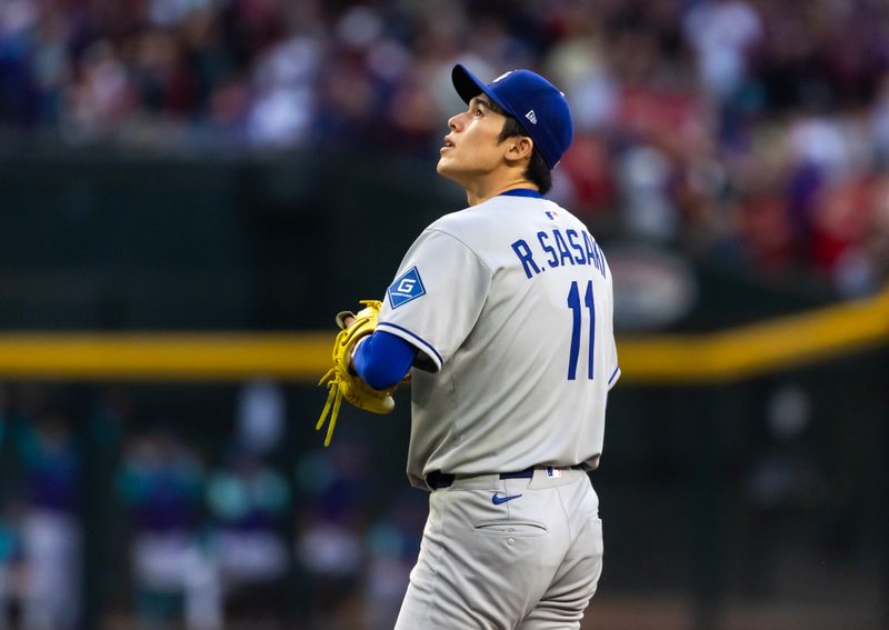 May 9, 2025; Phoenix, Arizona, USA; Los Angeles Dodgers pitcher Roki Sasaki reacts after giving up a home run to the Arizona Diamondbacks in the first inning at Chase Field. Mandatory Credit: Mark J. Rebilas-Imagn Images