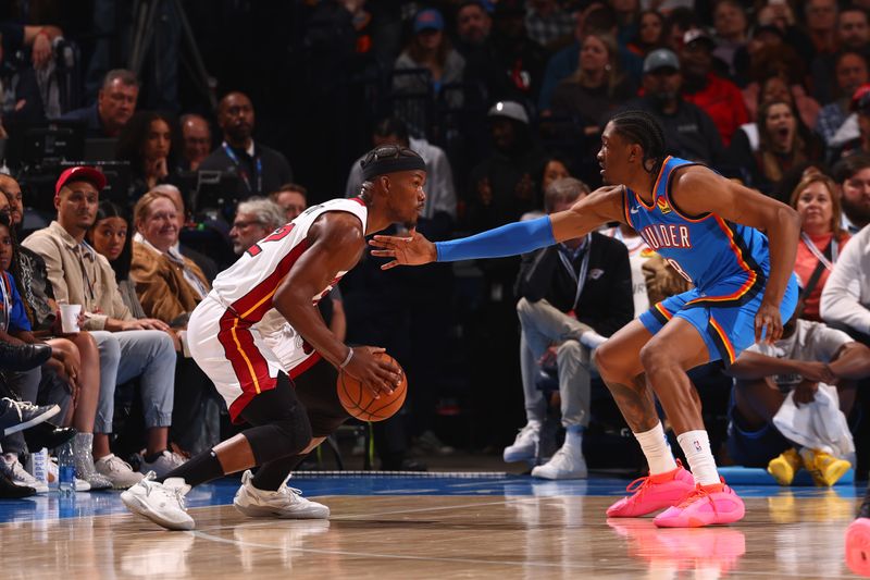 OKLAHOMA CITY, OK - MARCH 8:  Jimmy Butler #22 of the Miami Heat handles the ball during the game as Jalen Williams #8 of the Oklahoma City Thunder plays defense on March 8, 2024 at Paycom Arena in Oklahoma City, Oklahoma. NOTE TO USER: User expressly acknowledges and agrees that, by downloading and or using this photograph, User is consenting to the terms and conditions of the Getty Images License Agreement. Mandatory Copyright Notice: Copyright 2024 NBAE (Photo by Zach Beeker/NBAE via Getty Images)