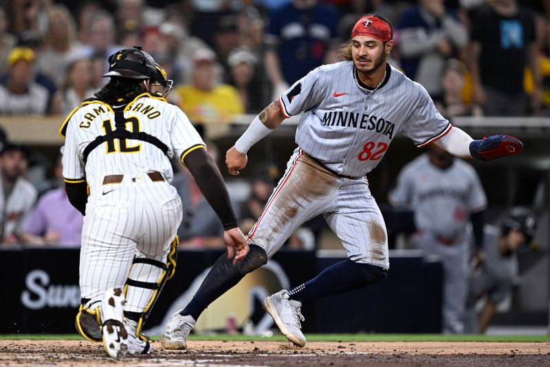 Aug 20, 2024; San Diego, California, USA; Minnesota Twins left fielder Austin Martin (82) is caught in a rundown as San Diego Padres catcher Luis Campusano (12) pursues during the fifth inning at Petco Park. Mandatory Credit: Orlando Ramirez-USA TODAY Sports