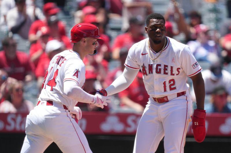 May 11, 2025; Anaheim, California, USA; Los Angeles Angels designated hitter Jorge Soler (12) is congratulated by catcher Logan O'Hoppe (14) after scoring in the first inning against the Baltimore Orioles at Angel Stadium. Mandatory Credit: Kirby Lee-Imagn Images