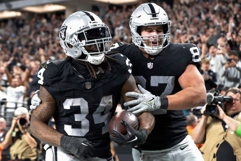 Las Vegas Raiders tight end Michael Mayer, right, celebrates after running back Brandon Bolden (34) scored a touchdown against the Los Angeles Chargers during the first half of an NFL football game, Thursday, Dec. 14, 2023, in Las Vegas. (AP Photo/Steve Marcus)