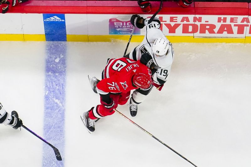 Jan 31, 2023; Raleigh, North Carolina, USA; Carolina Hurricanes defenseman Brady Skjei (76) checks Los Angeles Kings left wing Alex Iafallo (19) during the second period at PNC Arena. Mandatory Credit: James Guillory-USA TODAY Sports