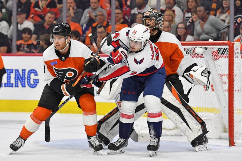 Apr 16, 2024; Philadelphia, Pennsylvania, USA; Washington Capitals center Connor McMichael (24) battles for position with Philadelphia Flyers defenseman Cam York (8) in front of goaltender Samuel Ersson (33) during the third period at Wells Fargo Center. Mandatory Credit: Eric Hartline-USA TODAY Sports