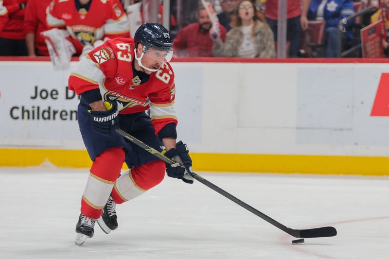 Apr 8, 2025; Sunrise, Florida, USA; Florida Panthers center Brad Marchand (63) moves the puck against the Toronto Maple Leafs during the second period at Amerant Bank Arena. Mandatory Credit: Sam Navarro-Imagn Images