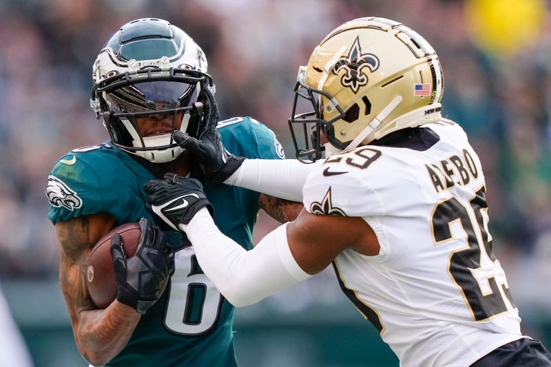 Philadelphia Eagles wide receiver DeVonta Smith (6) carries against New Orleans Saints cornerback Paulson Adebo (29) in the second half of an NFL football game in Philadelphia, Sunday, Jan. 1, 2023. (AP Photo/Matt Rourke)