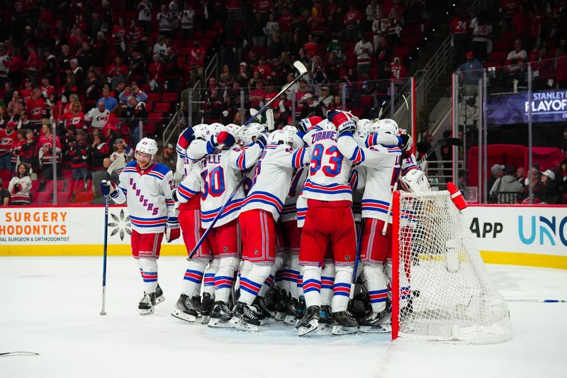 May 16, 2024; Raleigh, North Carolina, USA; New York Rangers players celebrate their victory against the Carolina Hurricanes in game six of the second round of the 2024 Stanley Cup Playoffs at PNC Arena. Mandatory Credit: James Guillory-USA TODAY Sports