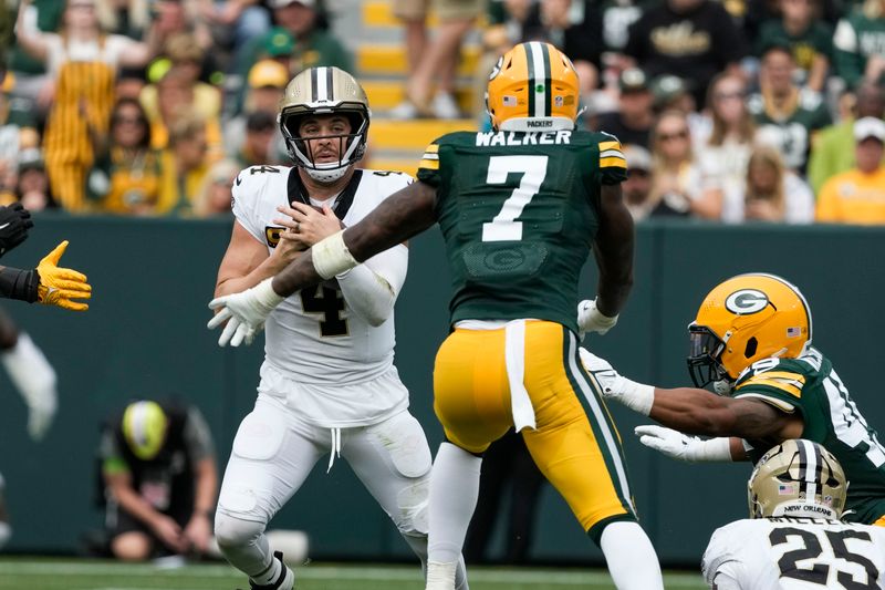 New Orleans Saints quarterback Derek Carr (4) scrambles under pressure rom Green Bay Packers linebacker Quay Walker (7) during the second half of an NFL football game Sunday, Sept. 24, 2023, in Green Bay, Wis. (AP Photo/Morry Gash)