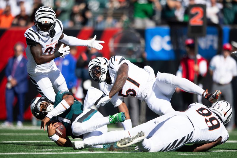 Philadelphia Eagles quarterback Jalen Hurts (1) is tackled on the play by Cincinnati Bengals linebacker Germaine Pratt (57) in the first half during an NFL football game on Sunday, Oct. 27, 2024, in Cincinnati. (AP Photo/Emilee Chinn)