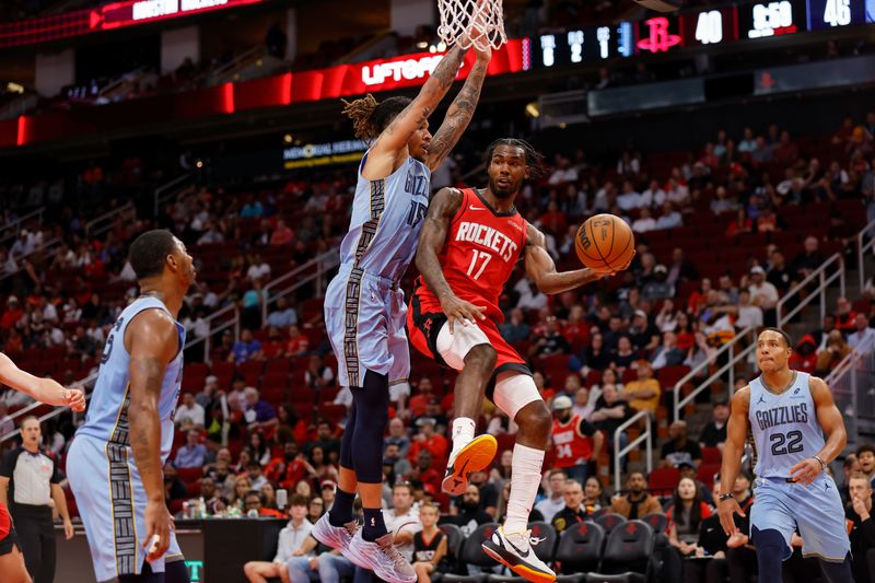 HOUSTON, TEXAS - OCTOBER 25: Tari Eason #17 of the Houston Rockets passes the ball while defended by Brandon Clarke #15 of the Memphis Grizzlies in the first half at Toyota Center on October 25, 2024 in Houston, Texas.  NOTE TO USER: User expressly acknowledges and agrees that, by downloading and or using this photograph, User is consenting to the terms and conditions of the Getty Images License Agreement.  (Photo by Tim Warner/Getty Images)