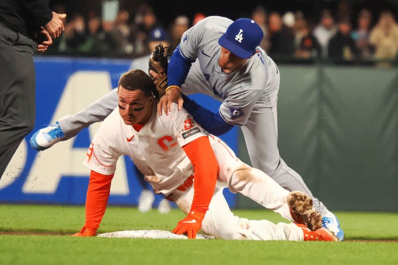 May 14, 2024; San Francisco, California, USA; San Francisco Giants third baseman Matt Chapman (26) collides with Los Angeles Dodgers second baseman Miguel Rojas (11) as he safely reaches second base on a double during the eighth inning at Oracle Park. Mandatory Credit: Kelley L Cox-USA TODAY Sports