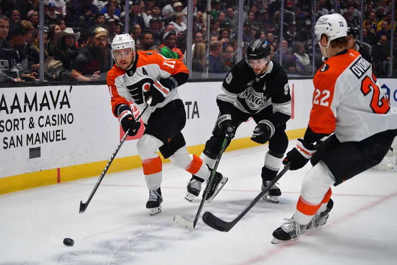 Mar 19, 2026; Los Angeles, California, USA; Philadelphia Flyers right wing Travis Konecny (11) passes the puck to center Christian Dvorak (22) against Los Angeles Kings right wing Adrian Kempe (9) during the first period at Crypto.com Arena. Mandatory Credit: Gary A. Vasquez-Imagn Images