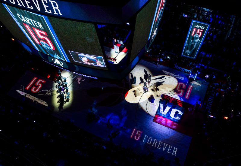 TORONTO, ON - NOVEMBER 2: Vince Carter, a former player of the Toronto Raptors, hugs his family as a banner is raised with the number 15 during his jersey retirement ceremony at half time in the game between the Toronto Raptors and the Sacramento Kings at the Scotiabank Arena on November 2, 2024 in Toronto, Ontario, Canada. NOTE TO USER: User expressly acknowledges and agrees that, by downloading and/or using this Photograph, user is consenting to the terms and conditions of the Getty Images License Agreement. (Photo by Mark Blinch/Getty Images)