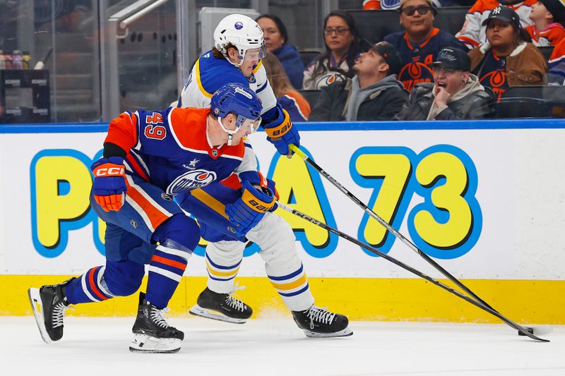 Jan 25, 2025; Edmonton, Alberta, CAN; Edmonton Oilers defensemen Ty Emberson (49) and Buffalo Sabres forward Take Thompson (72) battle along the boards for a loose puck  during the second period at Rogers Place. Mandatory Credit: Perry Nelson-Imagn Images