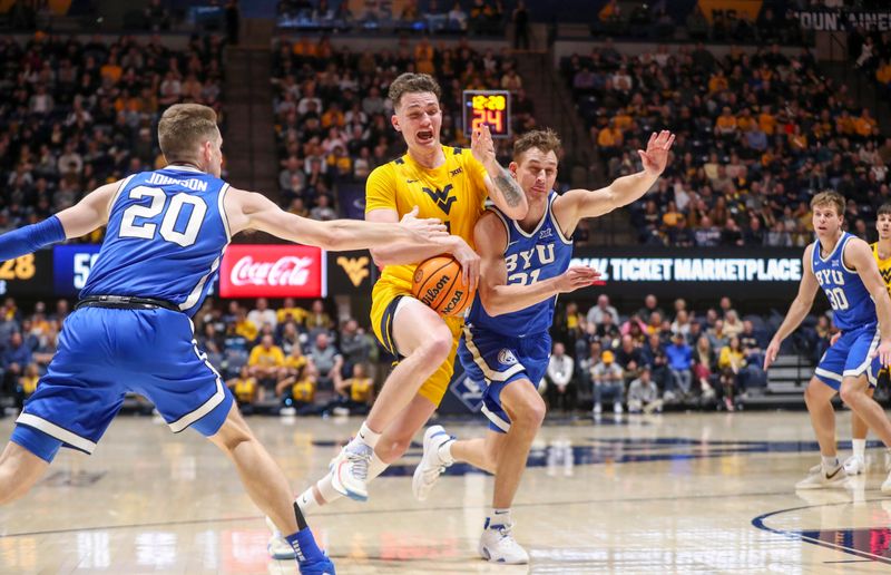 Feb 3, 2024; Morgantown, West Virginia, USA; West Virginia Mountaineers forward Quinn Slazinski (11) drives against Brigham Young Cougars guard Trevin Knell (21) during the second half at WVU Coliseum. Mandatory Credit: Ben Queen-USA TODAY Sports