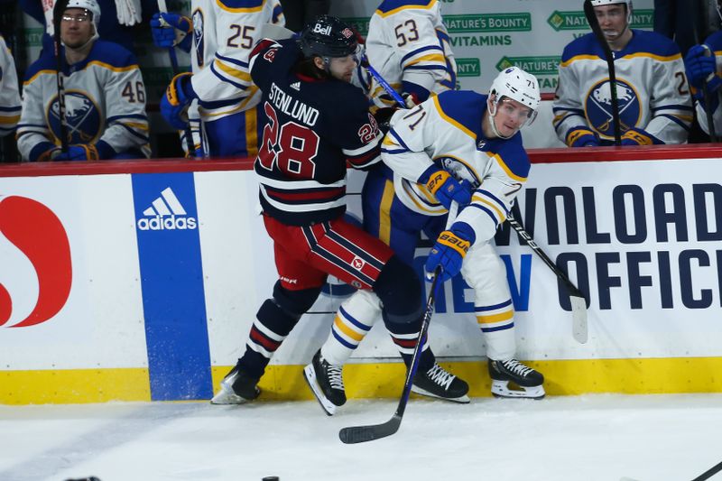 Jan 26, 2023; Winnipeg, Manitoba, CAN;  Buffalo Sabres forward Victor Olofsson (71) and Winnipeg Jets forward Kevin Stenlund (28) battle along the boards during the third period at Canada Life Centre. Mandatory Credit: Terrence Lee-USA TODAY Sports