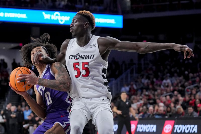 Jan 16, 2024; Cincinnati, Ohio, USA;  TCU Horned Frogs guard Micah Peavy (0) drives to the basket as he is fouled by Cincinnati Bearcats forward Aziz Bandaogo (55) in the second half at Fifth Third Arena. Mandatory Credit: Aaron Doster-USA TODAY Sports