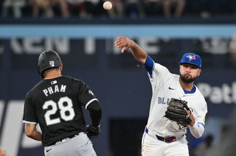 May 21, 2024; Toronto, Ontario, CAN;  Toronto Blue Jays second baseman Isiah Falefa-Kiner (7) throws to first base to complete a double play after forcing out Chicago White Sox center fielder Tommy Pham (28) in the seventh inning at Rogers Centre. Mandatory Credit: Dan Hamilton-USA TODAY Sports