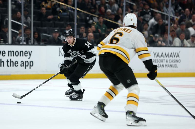 Nov 21, 2025; Los Angeles, California, USA;  Los Angeles Kings right wing Alex Laferriere (14) skates with the puck against Boston Bruins defenseman Mason Lohrei (6) during the overtime at Crypto.com Arena. Mandatory Credit: Kiyoshi Mio-Imagn Images