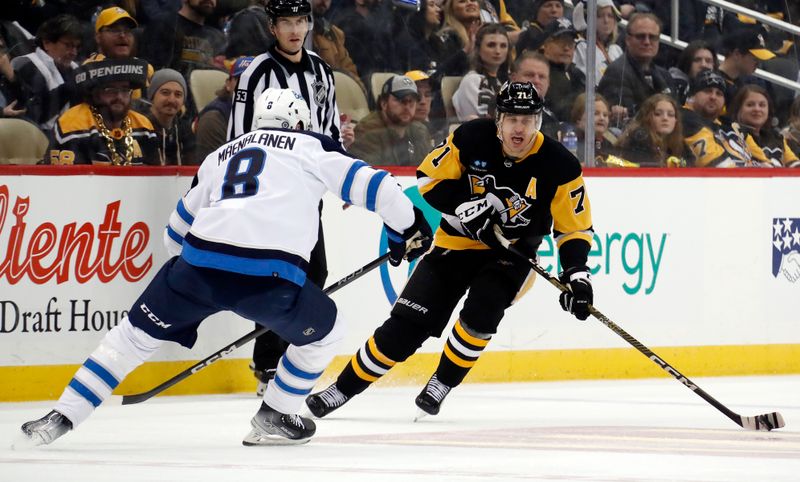 Jan 13, 2023; Pittsburgh, Pennsylvania, USA;  Pittsburgh Penguins center Evgeni Malkin (71) skates up ice with the puck as Winnipeg Jets right wing Saku Maenalanen (8) defends during the third period at PPG Paints Arena. The Jets won 4-1. Mandatory Credit: Charles LeClaire-USA TODAY Sports