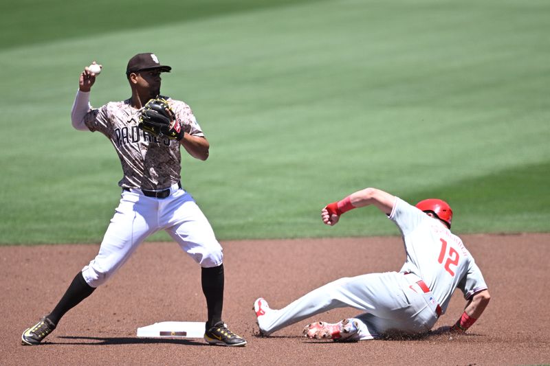 Apr 28, 2024; San Diego, California, USA; San Diego Padres second baseman Xander Bogaerts (left) throws to first base late after forcing out Philadelphia Phillies designated hitter Kyle Schwarber (12) at second base during the first inning at Petco Park. Mandatory Credit: Orlando Ramirez-USA TODAY Sports