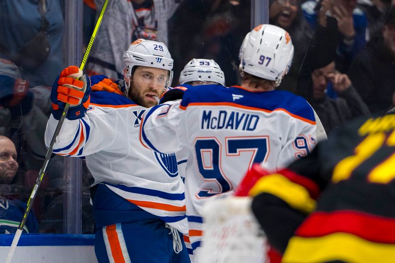 Nov 9, 2024; Vancouver, British Columbia, CAN; Edmonton Oilers forward Leon Draisaitl (29) and forward Ryan Nugent-Hopkins (93) and forward Connor McDavid (97) celebrate Draisaitl’s goal against the Vancouver Canucks during the first period at Rogers Arena. Mandatory Credit: Bob Frid-Imagn Images