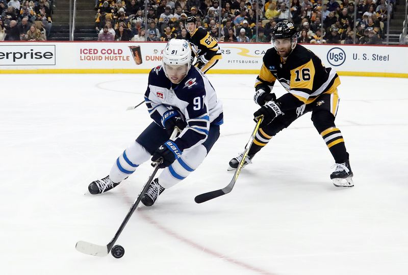 Jan 13, 2023; Pittsburgh, Pennsylvania, USA; Winnipeg Jets center Cole Perfetti (91) handles the puck against Pittsburgh Penguins left wing Jason Zucker (16) during the second period at PPG Paints Arena. Mandatory Credit: Charles LeClaire-USA TODAY Sports