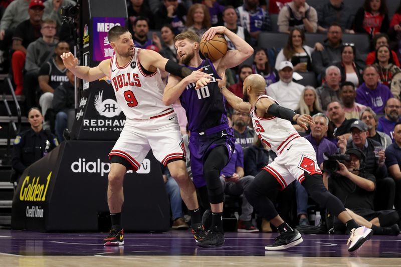 SACRAMENTO, CALIFORNIA - MARCH 04: Domantas Sabonis #10 of the Sacramento Kings is guarded by Nikola Vucevic #9 and Jevon Carter #5 of the Chicago Bulls in the first half at Golden 1 Center on March 04, 2024 in Sacramento, California. NOTE TO USER: User expressly acknowledges and agrees that, by downloading and or using this photograph, User is consenting to the terms and conditions of the Getty Images License Agreement.  (Photo by Ezra Shaw/Getty Images)