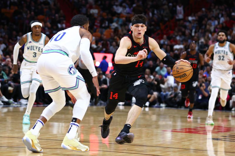 MIAMI, FLORIDA - DECEMBER 18: Tyler Herro #14 of the Miami Heat drives against Mike Conley #10 of the Minnesota Timberwolves during the third quarter of the game at Kaseya Center on December 18, 2023 in Miami, Florida. NOTE TO USER: User expressly acknowledges and agrees that, by downloading and or using this photograph, User is consenting to the terms and conditions of the Getty Images License Agreement. (Photo by Megan Briggs/Getty Images)