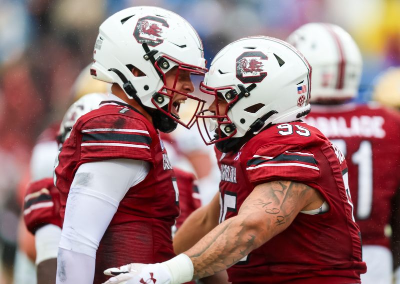 Nov 11, 2023; Columbia, South Carolina, USA; South Carolina Gamecocks defensive tackle Alex Huntley (95) celebrates with quarterback Spencer Rattler (7) after making a touchdown reception on offense against the Vanderbilt Commodores in the first quarter at Williams-Brice Stadium. Mandatory Credit: Jeff Blake-USA TODAY Sports