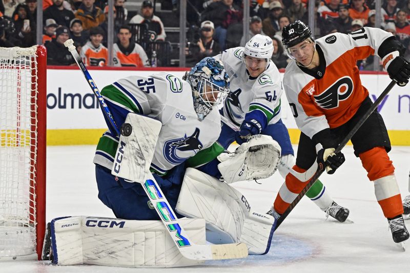 Dec 22, 2025; Philadelphia, Pennsylvania, USA; Vancouver Canucks goaltender Thatcher Demko (35) makes a save as Philadelphia Flyers right wing Bobby Brink (10) looks for the rebound during the second period at Xfinity Mobile Arena. Mandatory Credit: Eric Hartline-Imagn Images