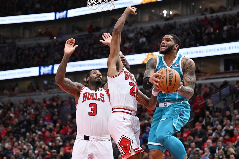 CHICAGO, ILLINOIS - JANUARY 05: Miles Bridges #0 of the Charlotte Hornets passes off the ball while being guarded by Andre Drummond #3 and Dalen Terry #25 of the Chicago Bulls in the second half on January 05, 2024 at United Center in Chicago, Illinois. Chicago defeated Charlotte 104-91. NOTE TO USER: User expressly acknowledges and agrees that, by downloading and or using this photograph, User is consenting to the terms and conditions of the Getty Images License Agreement. (Photo by Jamie Sabau/Getty Images)