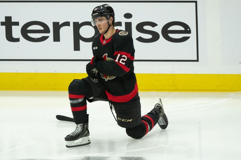 Dec 5, 2024; Ottawa, Ontario, CAN;  Ottawa Senators center Shane Pinto (12) stretches prior to the start of the third period against the Detroit Red Wings at the Canadian Tire Centre. Mandatory Credit: Marc DesRosiers-Imagn Images