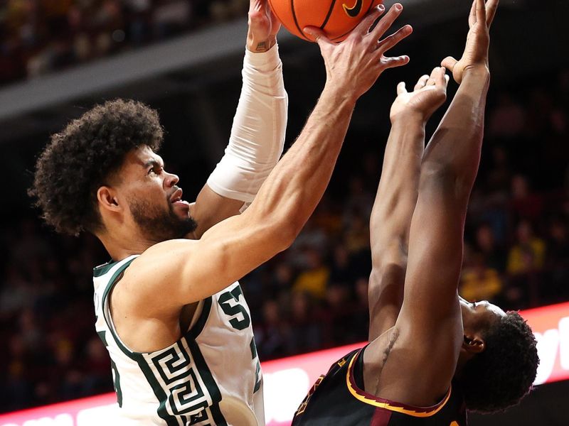 Feb 6, 2024; Minneapolis, Minnesota, USA; Michigan State Spartans forward Malik Hall (25) and Minnesota Golden Gophers forward Pharrel Payne (21) jump for the ball during the first half at Williams Arena. Mandatory Credit: Matt Krohn-USA TODAY Sports