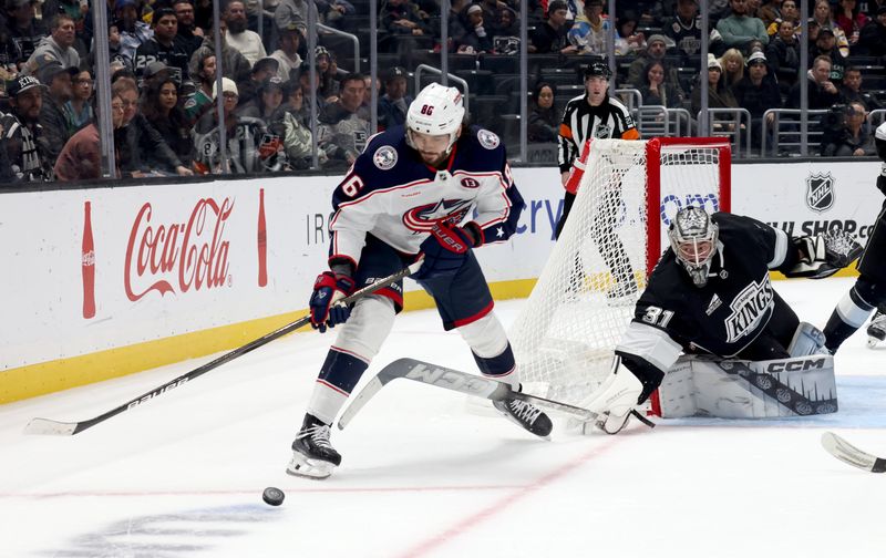 Nov 9, 2024; Los Angeles, California, USA; Los Angeles Kings goaltender David Rittich (31) pokes the puck away from Columbus Blue Jackets right wing Kirill Marchenko (86) during the third period at Crypto.com Arena. Mandatory Credit: Jason Parkhurst-Imagn Images