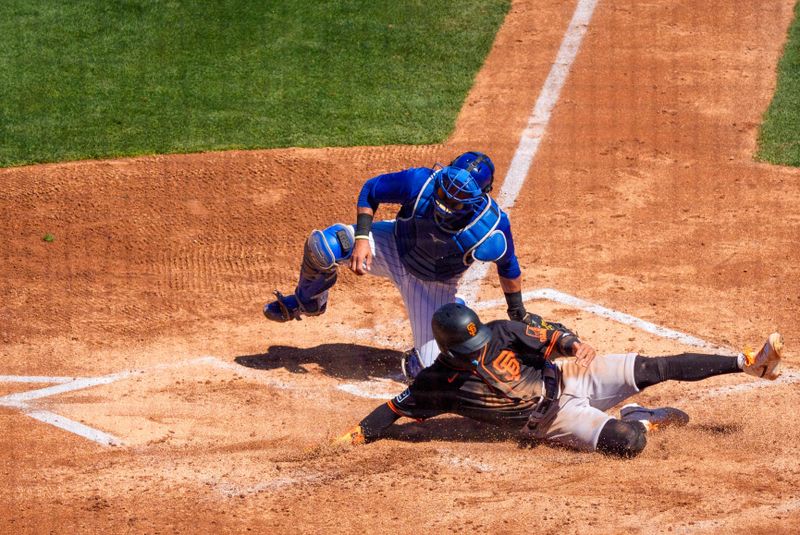 Mar 22, 2024; Mesa, Arizona, USA; San Francisco Giants outfielder Ismael Munguia (83) slides in to score in the third after Chicago Cubs catcher Yan Gomes (15) does not catch the ball thrown to home during a spring training game at Sloan Park. Mandatory Credit: Allan Henry-USA TODAY Sports