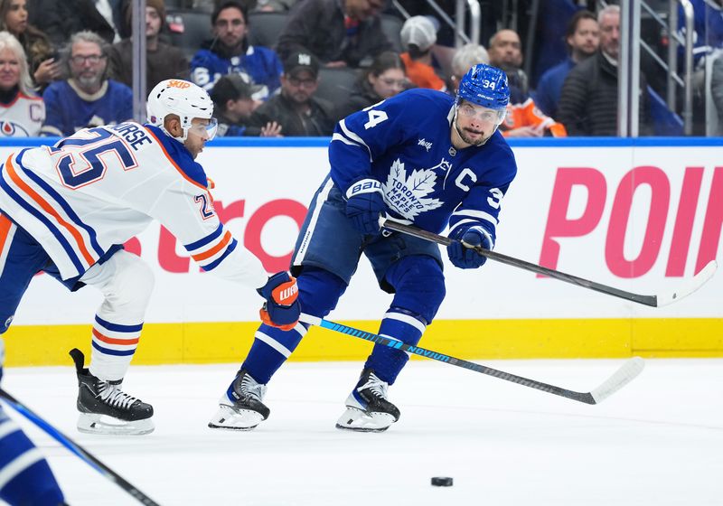 Dec 13, 2025; Toronto, Ontario, CAN; Toronto Maple Leafs center Auston Matthews (34) battles for the puck with Edmonton Oilers defenseman Darnell Nurse (25) during the third period at Scotiabank Arena. Mandatory Credit: Nick Turchiaro-Imagn Images
