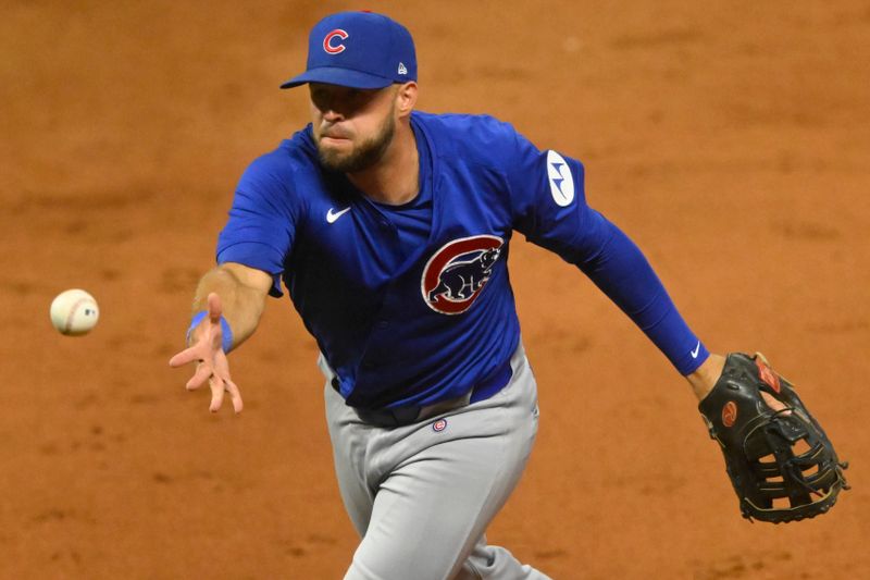 Aug 14, 2024; Cleveland, Ohio, USA; Chicago Cubs third baseman David Bote (13) tosses the ball to first base in the eighth inning against the Cleveland Guardians at Progressive Field. Mandatory Credit: David Richard-USA TODAY Sports