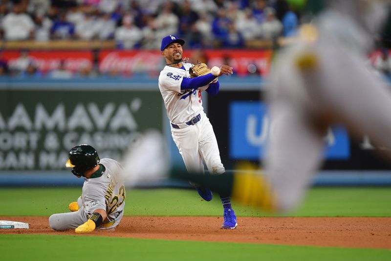 May 13, 2025; Los Angeles, California, USA; Athletics catcher Shea Langeliers (23) is out at second as Los Angeles Dodgers shortstop Mookie Betts (50) throws to first for the out against right fielder Lawrence Butler (4) during the fourth inning at Dodger Stadium. Mandatory Credit: Gary A. Vasquez-Imagn Images