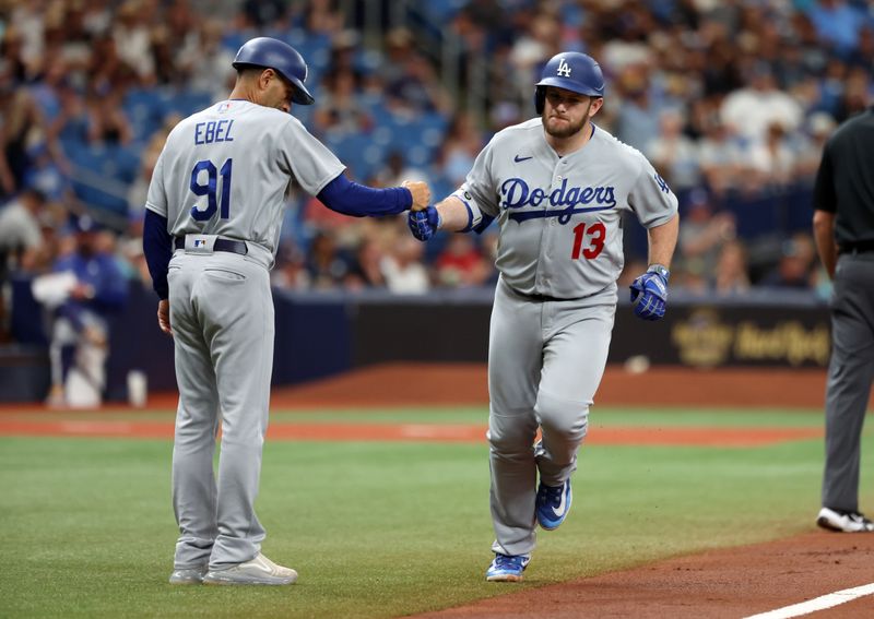 May 27, 2023; St. Petersburg, Florida, USA; Los Angeles Dodgers third baseman Max Muncy (13) fist pumps third base coach Dino Ebel (91) after hitting a home run against the Tampa Bay Rays during the second inning at Tropicana Field. Mandatory Credit: Kim Klement-USA TODAY Sports