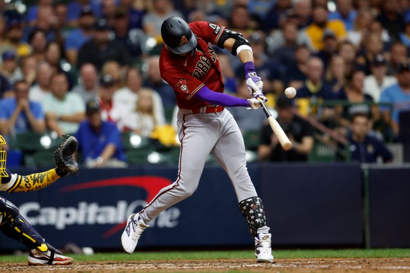 Oct 4, 2023; Milwaukee, Wisconsin, USA; Arizona Diamondbacks left fielder Lourdes Gurriel Jr. (12) hits a RBI single in the sixth inning against the Milwaukee Brewers during game two of the Wildcard series for the 2023 MLB playoffs at American Family Field. Mandatory Credit: Kamil Krzaczynski-USA TODAY Sports