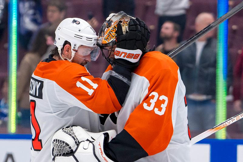 Oct 11, 2024; Vancouver, British Columbia, CAN; Philadelphia Flyers forward Travis Konecny (11) and goalie Samuel Ersson (33) celebrate their victory against the Vancouver Canucks at Rogers Arena. Mandatory Credit: Bob Frid-Imagn Images