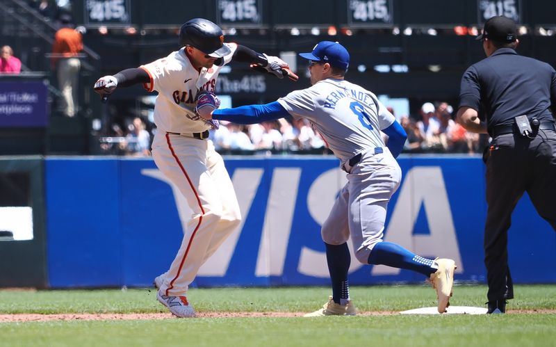 Jun 30, 2024; San Francisco, California, USA; San Francisco Giants shortstop Nick Ahmed (16) is tagged out by Los Angeles Dodgers shortstop Enrique Hernandez (8) during the second inning at Oracle Park. Mandatory Credit: Kelley L Cox-USA TODAY Sports