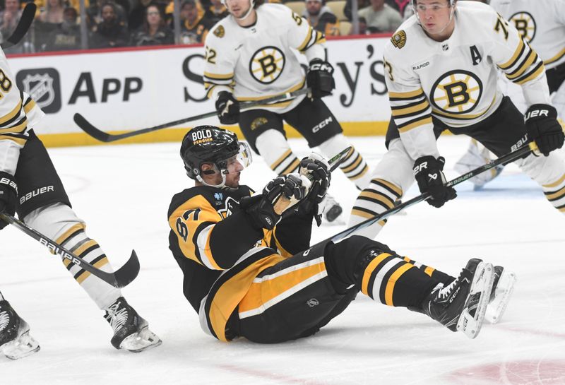 Apr 13, 2024; Pittsburgh, Pennsylvania, USA; Pittsburgh Penguins center Sidney Crosby (87) sits on the ice while taking a stick from Boston Bruins defenseman Charlie McAvoy (73) during the first period at PPG Paints Arena. Mandatory Credit: Philip G. Pavely-USA TODAY Sports