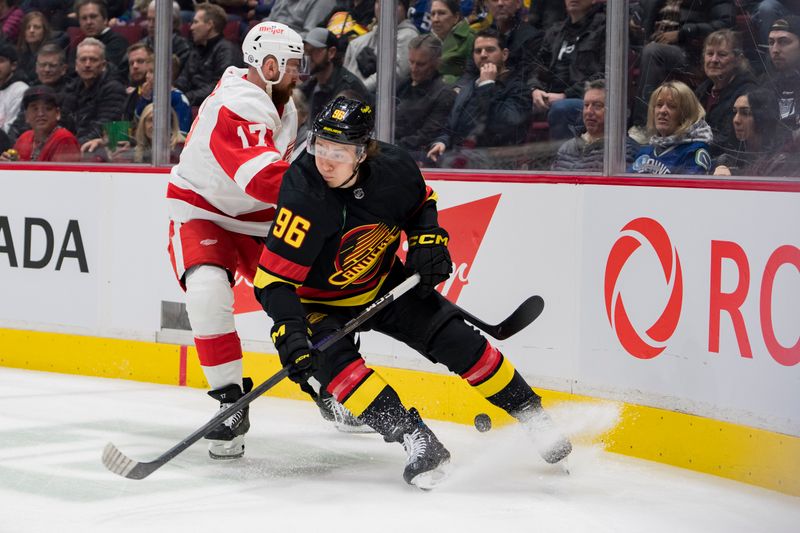 Feb 13, 2023; Vancouver, British Columbia, CAN; Detroit Red Wings defenseman Filip Hronek (17) checks Vancouver Canucks forward Andrei Kuzmenko (96) in the first period at Rogers Arena. Mandatory Credit: Bob Frid-USA TODAY Sports